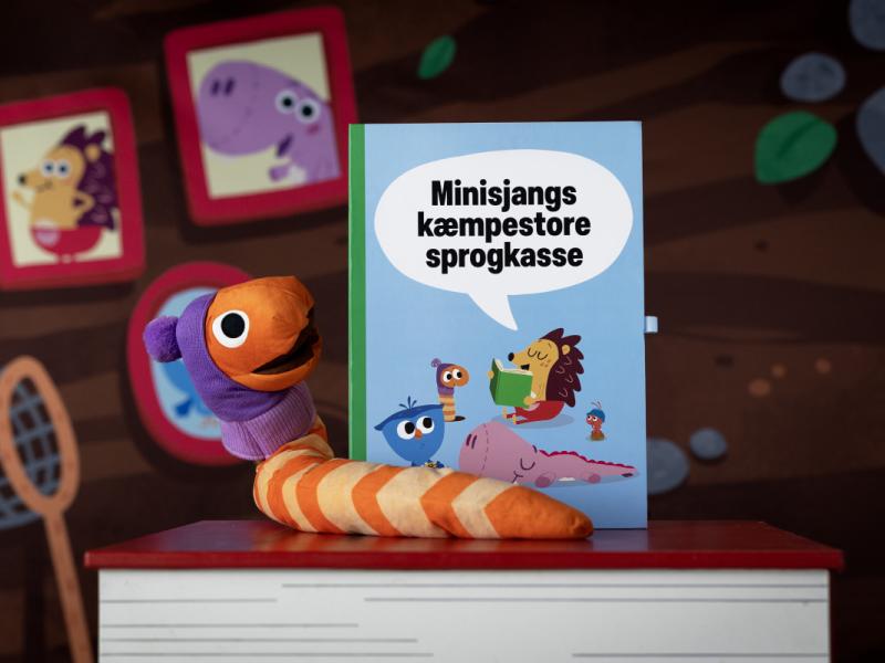 Orm fra DR Minisjangs Børste-univers sidder på en stor børn sammen med Minisjangs kæmpestore sprogkasse